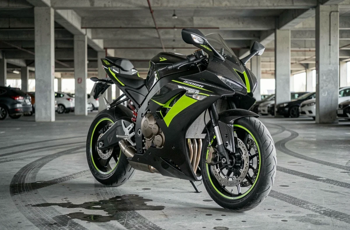 Moto hypersportive noire et verte garée dans un parking urbain, vue en angle trois-quarts avant mettant en valeur son design agressif et ses équipements haute performance liés aux primes d'assurance élevées