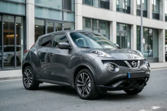 Nissan Juke gris métallisé garé dans une rue urbaine moderne, vue trois quarts avant mettant en valeur son design sculptural