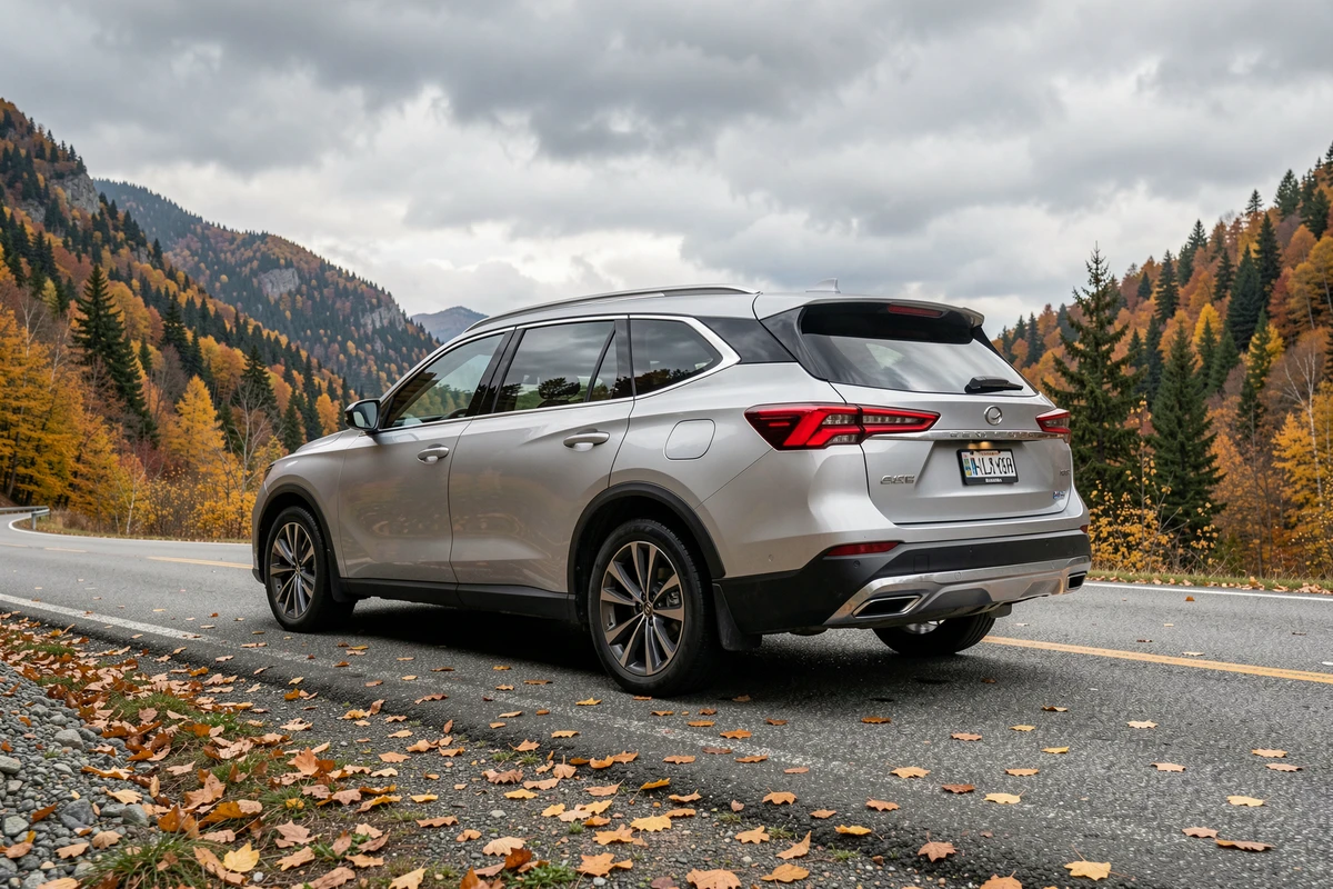 Grand SUV Peugeot 5008 en route sur une route de montagne entourée de forêts aux couleurs automnales, vue arrière trois quarts
