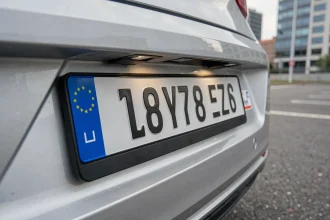 Gros plan d'une plaque d'immatriculation française SIV sur un véhicule moderne dans un parking urbain